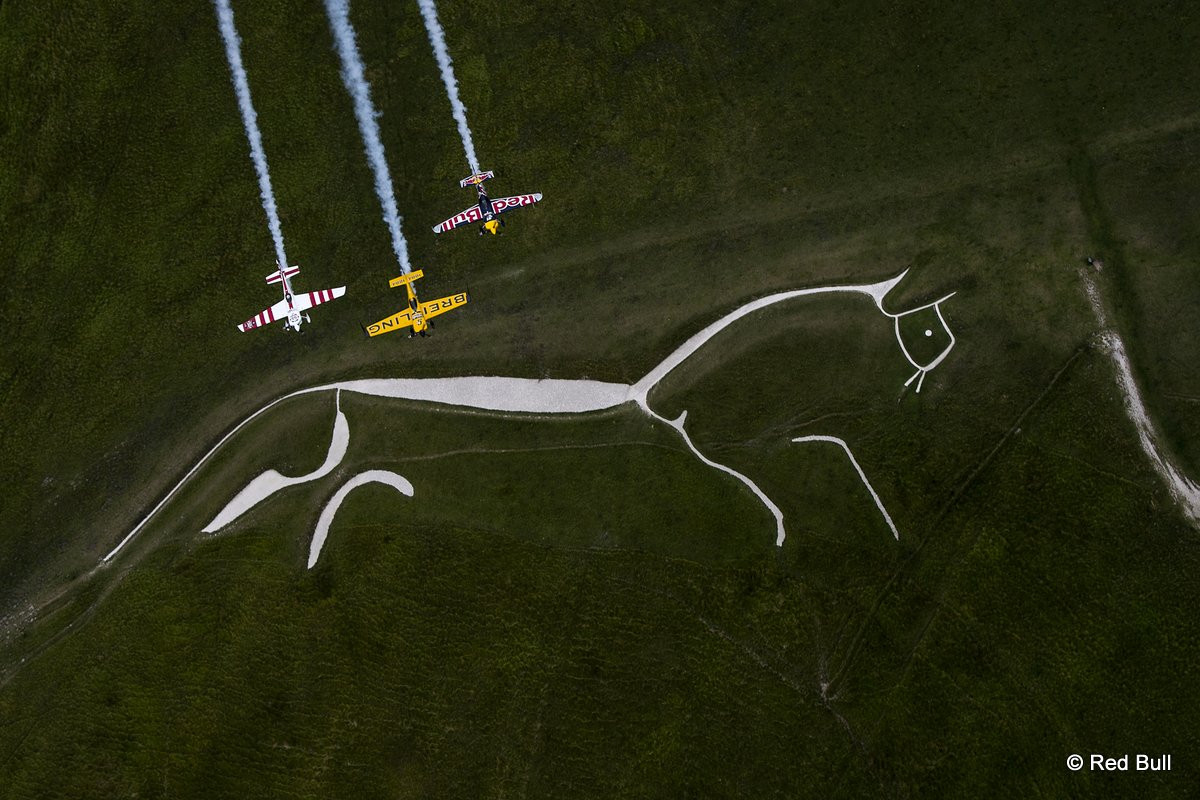 Nigel Lamb and Paul Bohomme of Great Britain give Peter Besenyei of Hungary an aerial view of their home country ahead of the weekend\'s Red Bull Air Race World Championship stop in Ascot over the Uffington White Hores in the Oxfordshire countryside near Oxford in the United Kingdom on August 11, 2015.