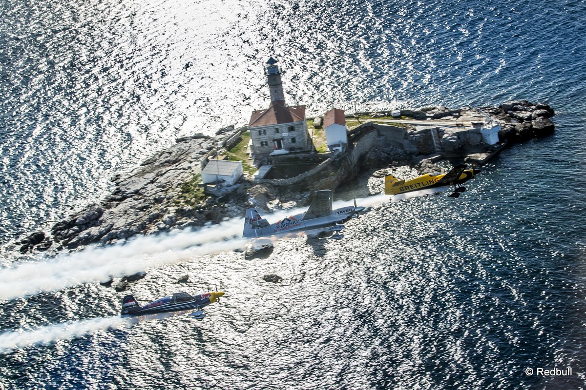 Nigel Lamb of Great Britain, Hannes Arch of Austria and Peter Besenyei of Hungary fly in formation in front of the lighthouse tower of Rovinj prior to the second stage of the Red Bull Air Race World Championship in Rovinj, Croatia on April 10, 2014.