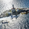 Nigel Lamb of Great Britain, Hannes Arch of Austria and Peter Besenyei of Hungary fly in formation in front of the lighthouse tower of Rovinj prior to the second stage of the Red Bull Air Race World Championship in Rovinj, Croatia on April 10, 2014.