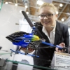 Eine Mitarbeiterin der Firma Jamara Germany e.K. stellt einen Helikopter vom Model e-rix 250 mit Blatthaltern aus eloxiertem Aluminium in eine Vitrine (An employee of the company Jamara Germany e.K. places a helicopter from Model e-rix 250 with blade holders made from anodised aluminum in a showcase)
